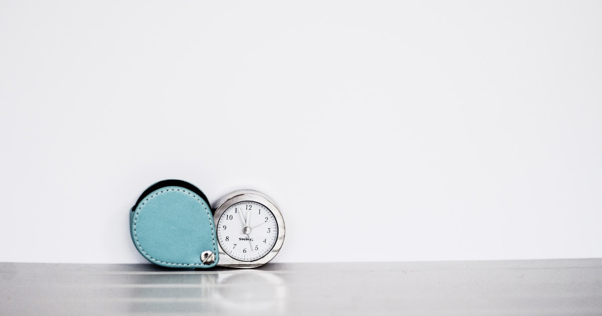 Gray and white clock against a pale blue background