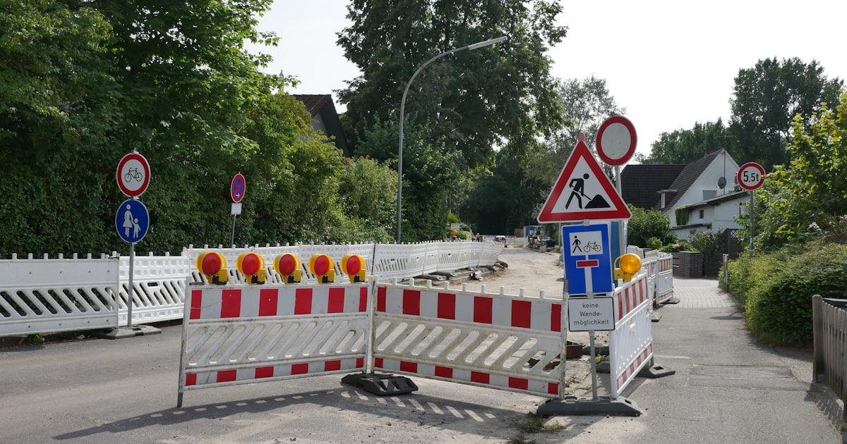 Road closed by red and white construction barricades and traffic signs