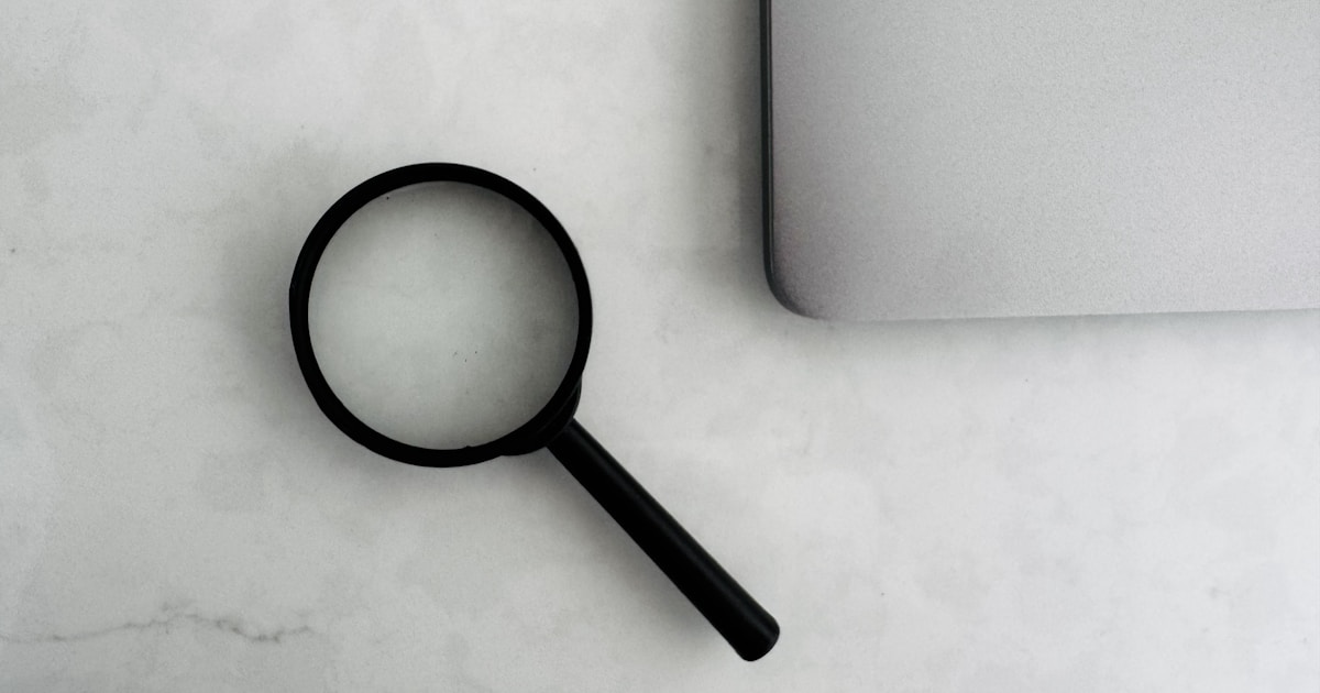 Magnifying glass beside the corner of a laptop