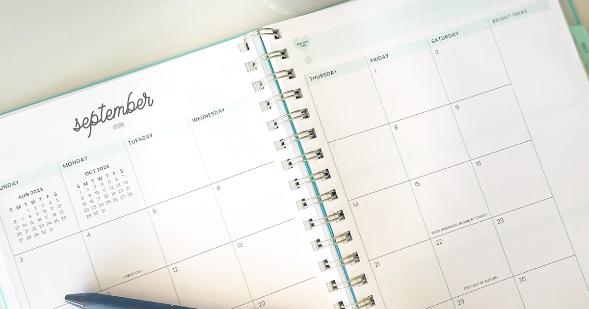 Open planner beside an hourglass and clock